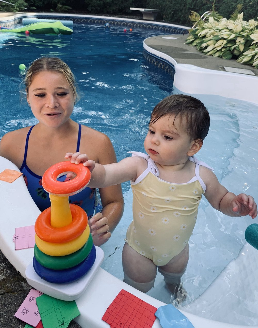 Une monitrice aquatique surveille et joue avec un bébé dans une piscine creusée