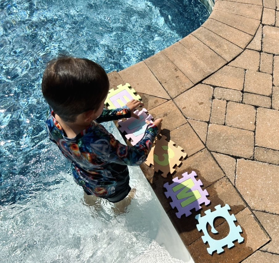Un enfant joue au bord de la piscine avec des jouets aquatique