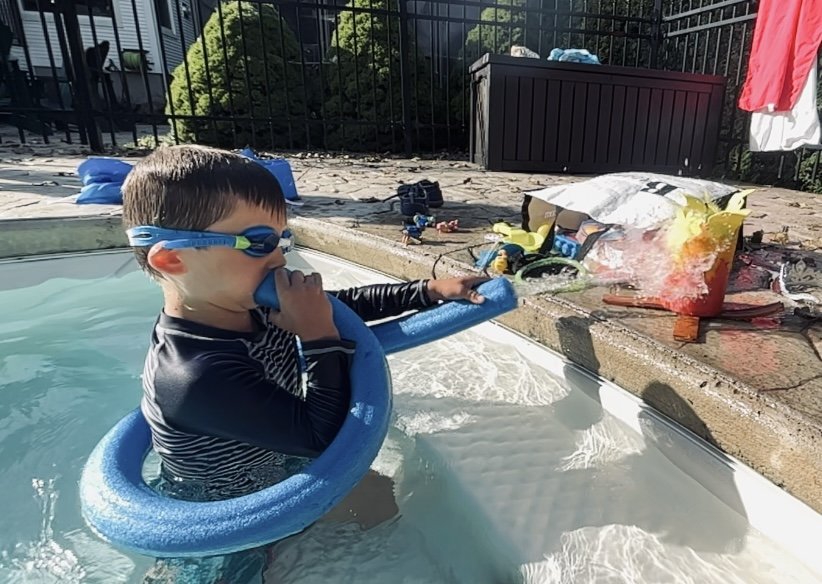 Un jeune garçon joue dans une piscine